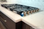 Угловая кварцевая столешница для кухни под светлый мрамор фото